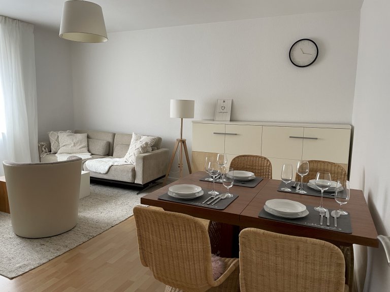 Geräumiges Wohnzimmer mit Essplatz, gemütlichem Sofa und integriertem Schrankbett in der Ferienwohnung Mönchengladbach-Eicken